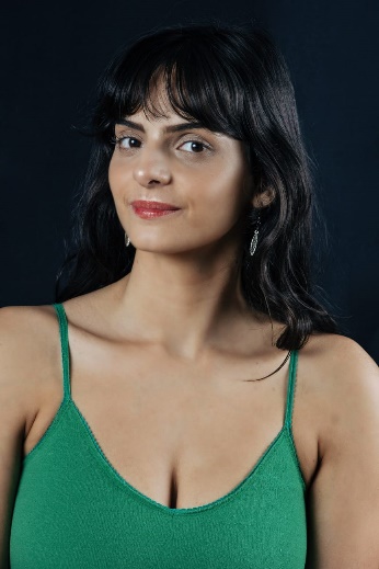 A person with dark hair wearing a green dress

AI-generated content may be incorrect.